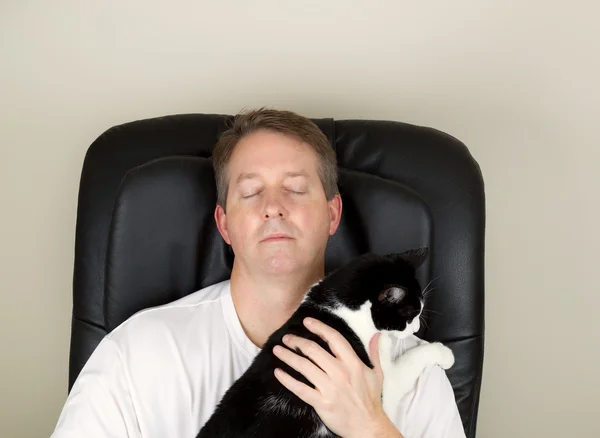 Mature Man and his cat relaxing in massage chair — Stock Photo, Image