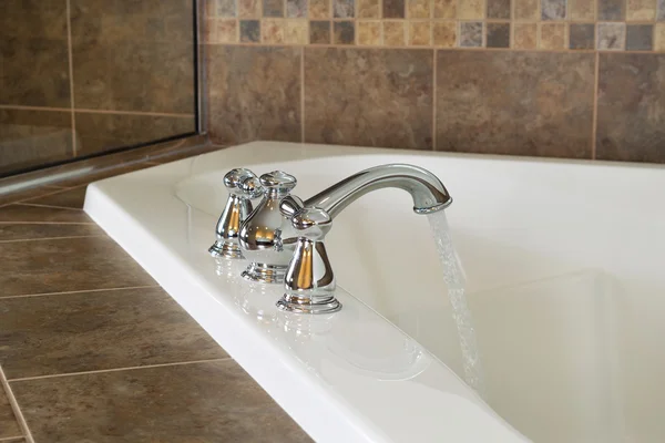 Rinnande vatten in i master badkar — Stockfoto