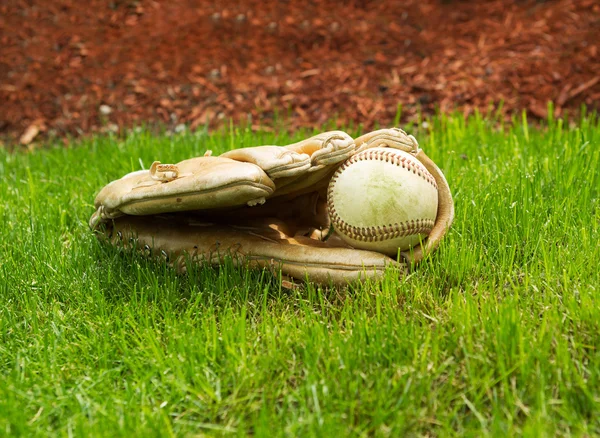 Velho beisebol dentro da luva usada no chão — Fotografia de Stock