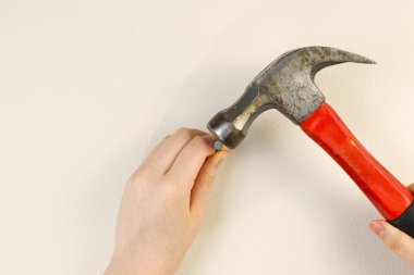 tutan elleri çekiç ve ev iç duvara çivi