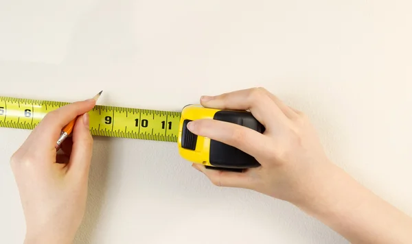 Nastro di misura e matita si prepara a segnare parete interna — Foto Stock