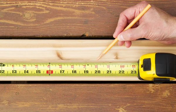 Hand measuring wooden board — Stock Photo, Image