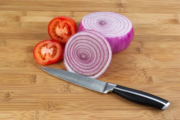 taze domates ve soğan kesme tahtası üzerinde 