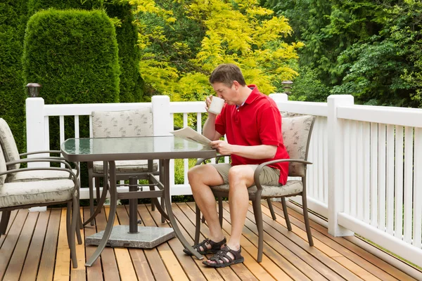 Mature Man Enoying Morning Coffee on Outdoor Patio in Morning