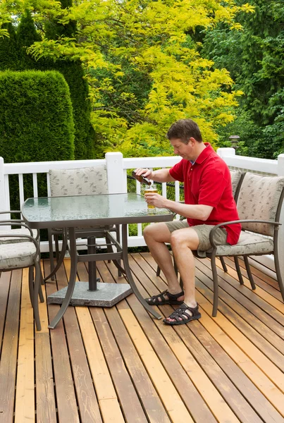 Człowiek dojrzały do picia w tabeli na zewnątrz otwarte patio — Zdjęcie stockowe