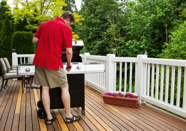 Volwassen man draaien op barbecu grill terwijl buiten op het open dek — Stockfoto