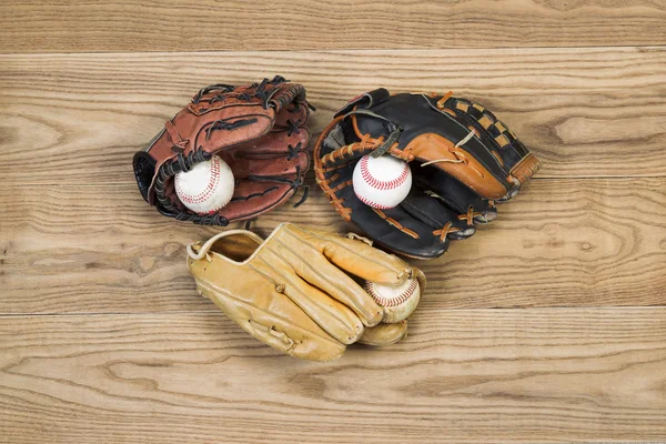 Oude honkbal handschoenen en ballen op leeftijd hout — Stockfoto