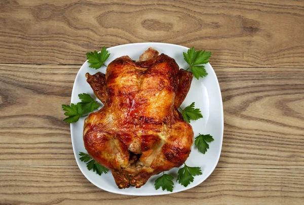 Pollo entero asado al horno fresco con perejil en la placa de servir —  Fotos de Stock