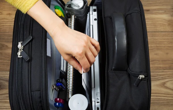 Mano femminile che estrae materiale per ufficio dalla borsa da viaggio — Foto Stock