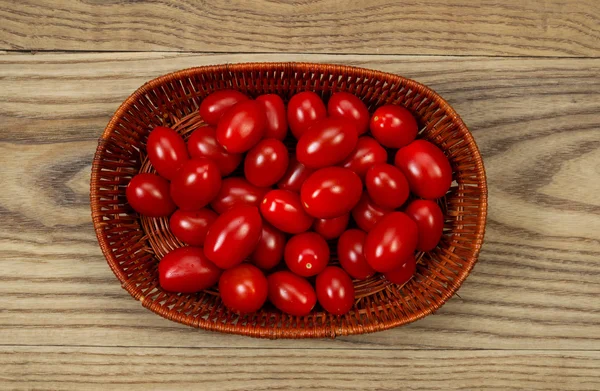 Cesta de tomates de uva frescos en madera de edad —  Fotos de Stock