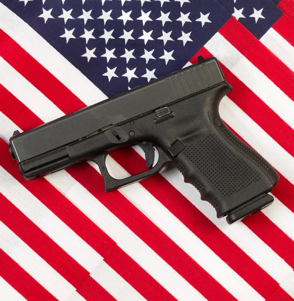 Pistola encima de banderas americanas — Foto de Stock