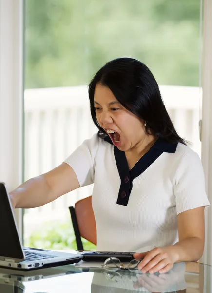 Mujer madura expresando ira extrema mientras mira a su compu — Foto de Stock