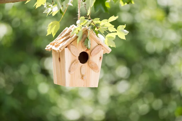 Nytt trä fågelholk hängande på trädgren utomhus — Stockfoto