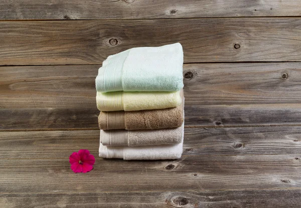 Clean Towels and single pink flower on Weathered Wood — Stock Photo, Image