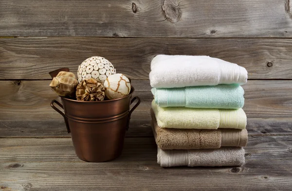 Saubere gestapelte Handtücher und mit Dekorationen gefüllte Eimer auf dem Boden — Stockfoto