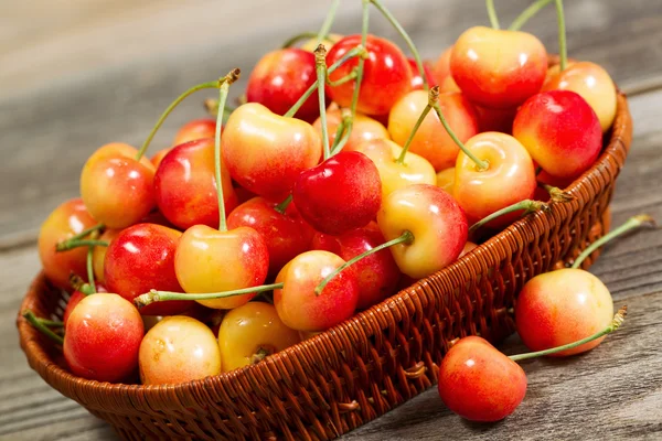 Cerezas Golden Rainier recién recogidas en cesta sobre madera rústica —  Fotos de Stock