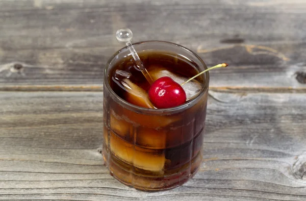 Rum und Cola mit großer roter Kirsche — Stockfoto