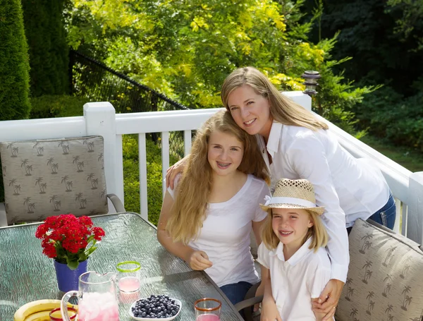 Happy mother and her daughters sharing a hug during breakfast — Stock Photo, Image