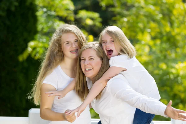 Mother giving younger daughter piggy back ride — Stock Photo, Image