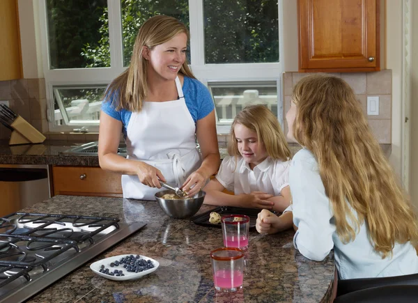 Mother and daughters making cookies from raw dough — Stock Photo, Image