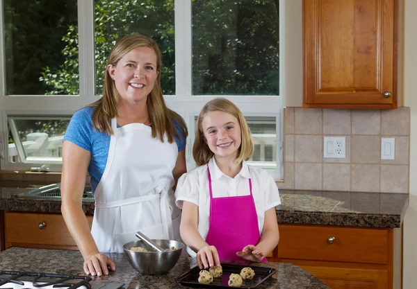 Happy mother and daughter making cookies — Stock Photo, Image