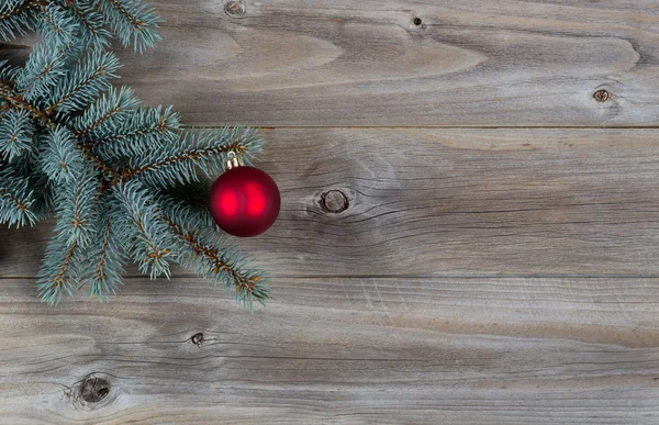 Κόκκινη μπάλα Χριστουγεννιάτικο στολίδι στο κλαδί πεύκου με ρουστίκ ξύλο — Φωτογραφία Αρχείου