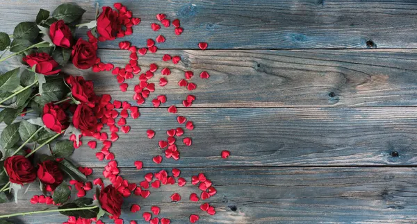 バレンタインデーの背景に小さな心の形と赤いバラの境界線で色あせた青い木の板 — ストック写真