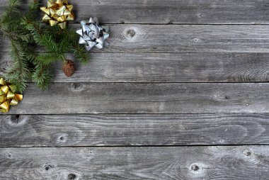 Köknar dalları ve parlak altın ve gümüş hediyeli tek bir çam kozalağının en üst görüntüsü Mutlu Noeller için eski ahşap kalaslarda