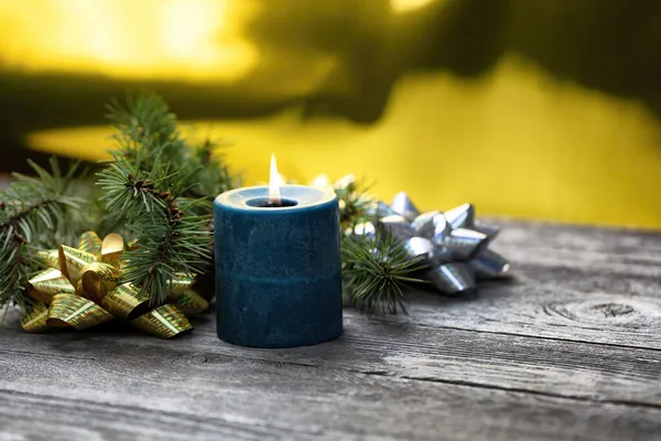 Nahaufnahme Einer Brennenden Blauen Kerze Mit Goldenem Hintergrund Sowie Tannenzweigen — Stockfoto