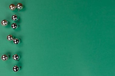 Yeşil arka planda parlak top süslemeleri olan mutlu noeller ya da mutlu noeller. 