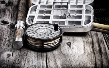 Antika sinek makarası, olta ve kırsal ahşap tahtalara yem konteynırı konmuş iniş ağı. Makara üzerine seçmeli odak. 