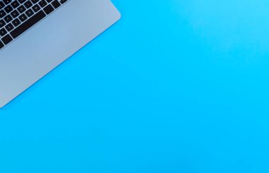 Laptop bilgisayarlı mavi ofis masası. Kabartma düzeninde kopyalama alanı olan üst görünüm. Okul ya da iş kavramı. 