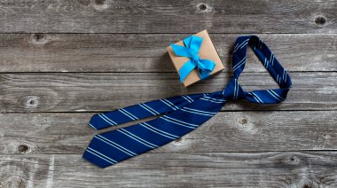 Düğümlü kravat ve hediye kutusuyla Babalar Günü tatili konsepti düz görünümde. 