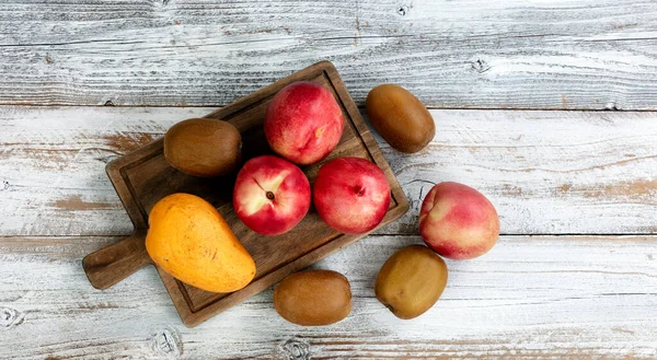 White Rustic Table Assorted Fruit Consisting Peach Kiwi Mango Overhead — Stock Fotó