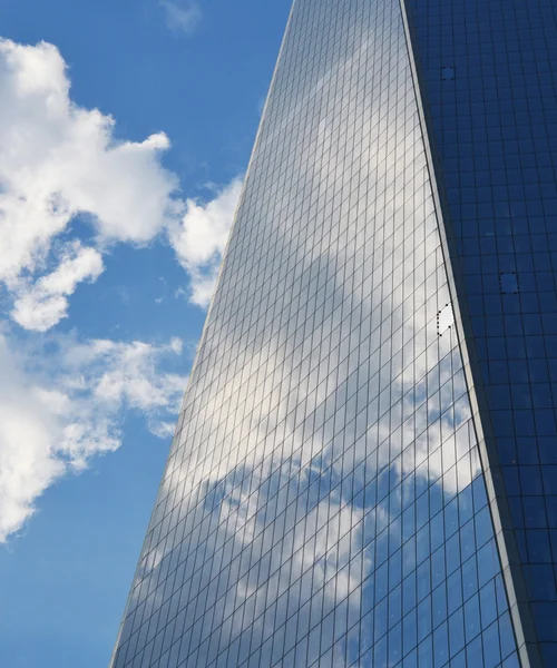 多云的天空映照在一座摩天大楼的窗户 — 图库照片