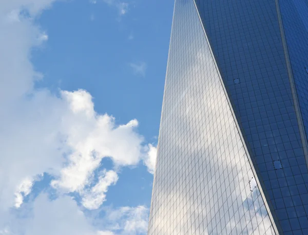 多云的天空映照在一座摩天大楼的窗户 — 图库照片
