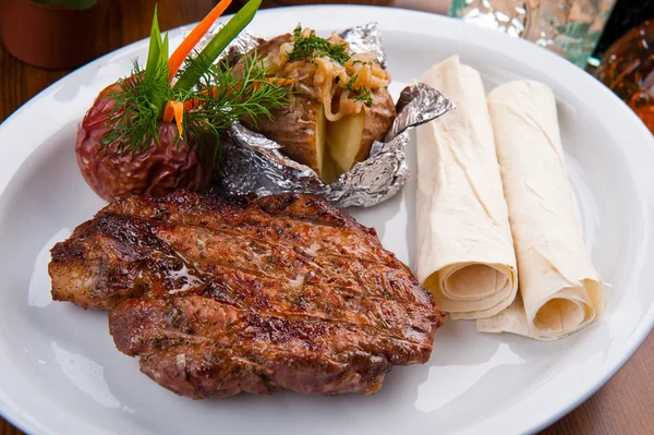 Gegrilltes Fleisch und Kartoffeln auf dem Teller — Stockfoto