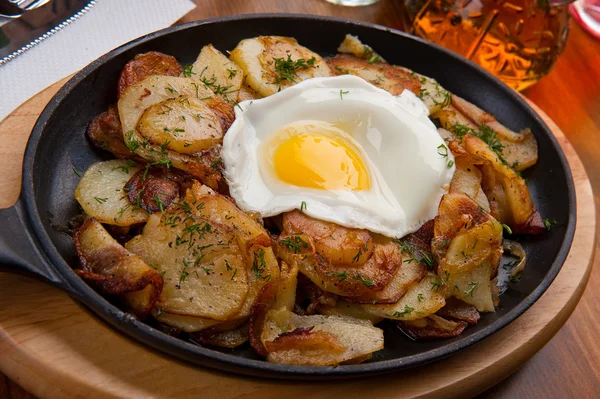 Patatas fritas con un huevo en una sartén —  Fotos de Stock