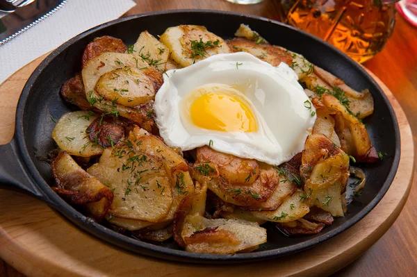 Patatas fritas con un huevo en una sartén — Foto de Stock