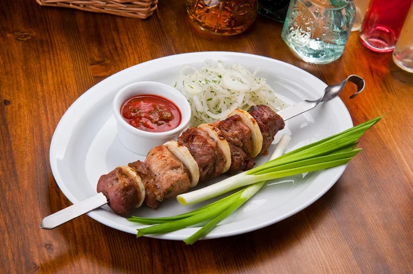 Shish kebab met saus en Groenen op een plaat — Stockfoto