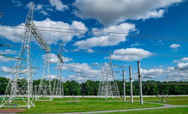 Mavi gökyüzüne karşı yüksek voltajlı elektrik ağı