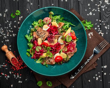 Taze sebzeli sığır dili salatası, soğan turşusu ve bir tabakta mini mısır..