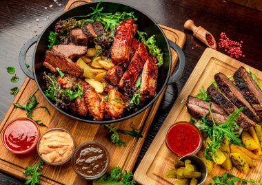 Farklı türde et, tavuk, dana eti, ızgara domuz eti. Patatesli tavada servis yap. BBQ eti