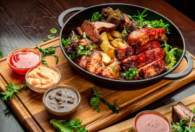 Farklı türde et, tavuk, dana eti, ızgara domuz eti. Patatesli tavada servis yap. BBQ eti