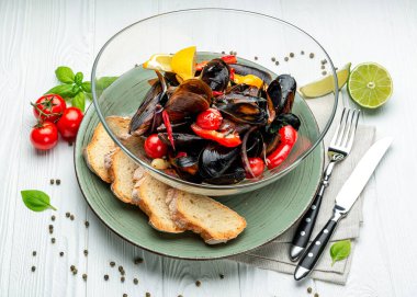 Çeşitli sebzeler, baharatlar ve kıtır ekmeklerle haşlanmış midye servis ediyorlar.