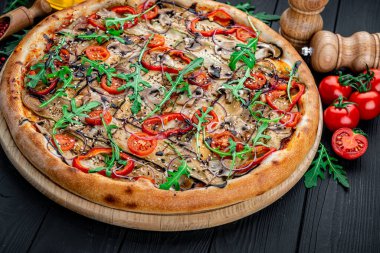 Restoranda yemek servisi. Patlıcan, kırmızı biber, domates, peynir ve kabaklı vejetaryen etsiz pizza.