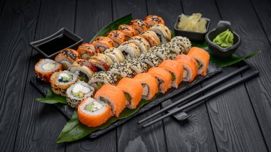 Suşi restoranda Japon yemeği yapar. California suşi seti, somon, sebze, uçan balık yumurtası ve havyar yakın plan. Japon restoran menüsü