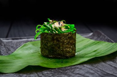 Koyu arkaplanda chuka yosunlu suşi rulo gunkan