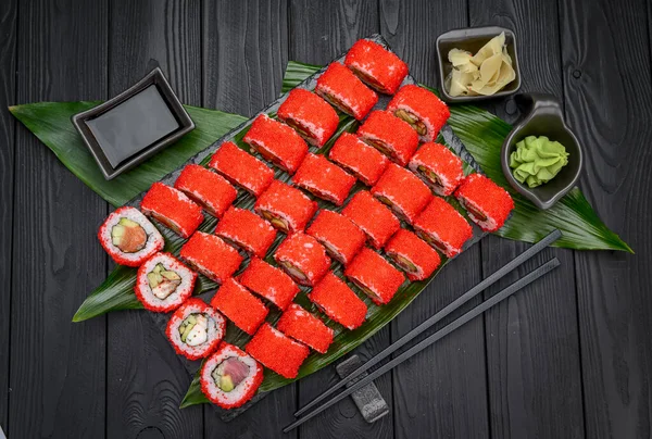 Sushi roll japanese food in restaurant. California Sushi roll set with salmon, vegetables, flying fish roe and caviar closeup. Japan restaurant menu