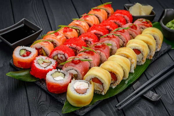 Sushi roll japanese food in restaurant. California Sushi roll set with salmon, vegetables, flying fish roe and caviar closeup. Japan restaurant menu